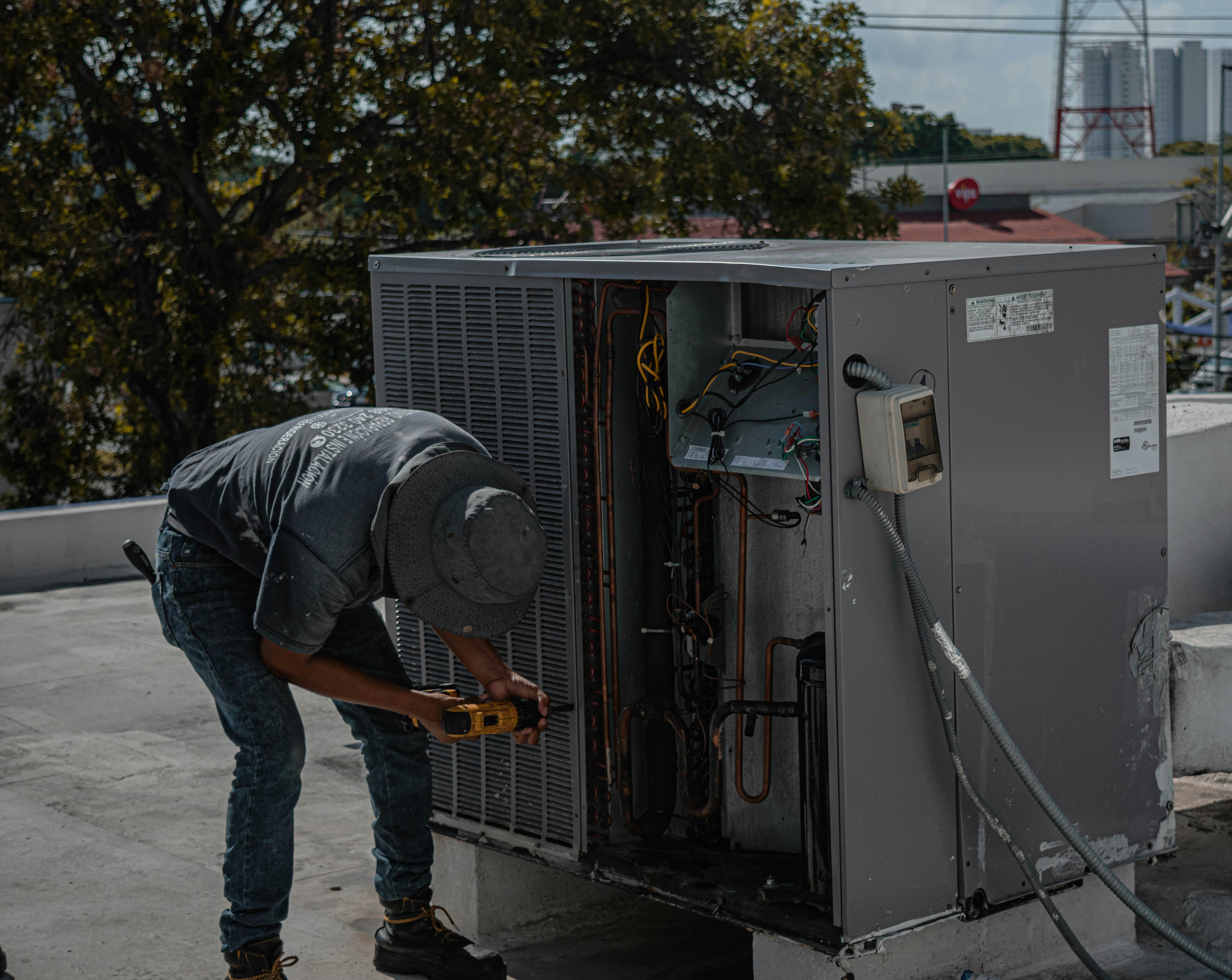 Technician repairing rooftop HVAC system